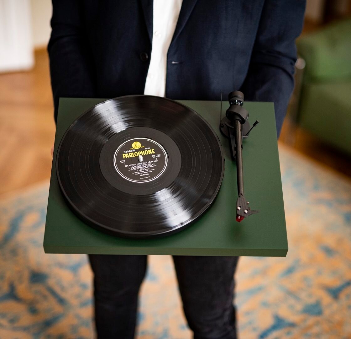 Toca-discos Pro-Ject Debut Carbon EVO verde com disco de vinil, braço de fibra de carbono, contrapeso e cápsula vermelha