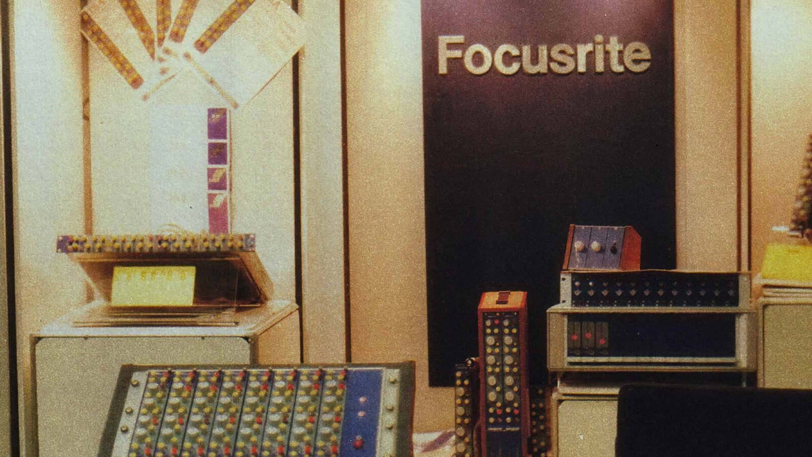 Foto de arquivo de um estande da Focusrite nos anos 1980, com módulos ISA e um console compacto em exposição