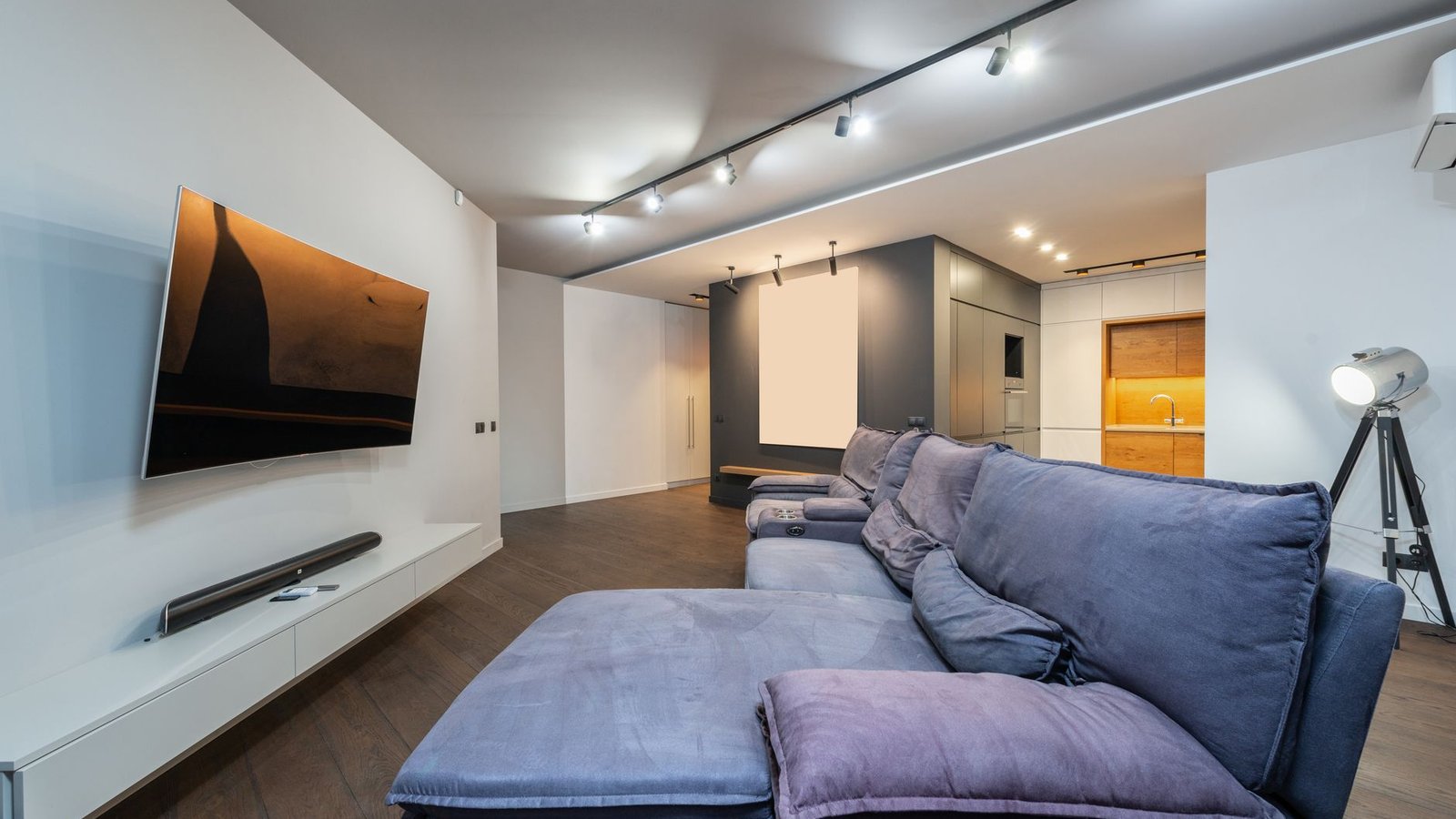 Sala de estar contemporânea com TV pendurada e soundbar preta horizontal sobre móvel branco
