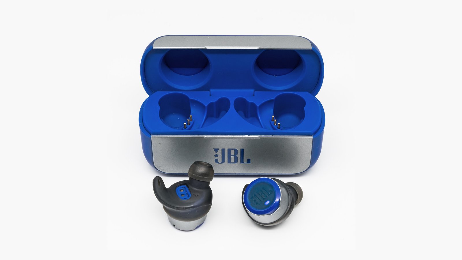 História da JBL: fone de ouvido sem fio JBL com estojo de carregamento azul e prata, dois fones fora do estojo, mostrando design ergonômico e detalhes da marca