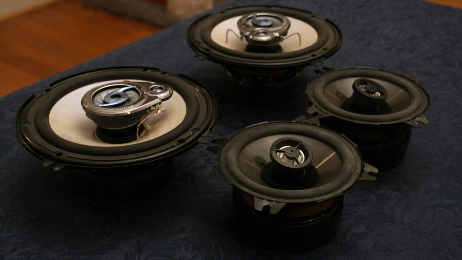 Quatro alto-falantes automotivos coaxiais sobre uma mesa