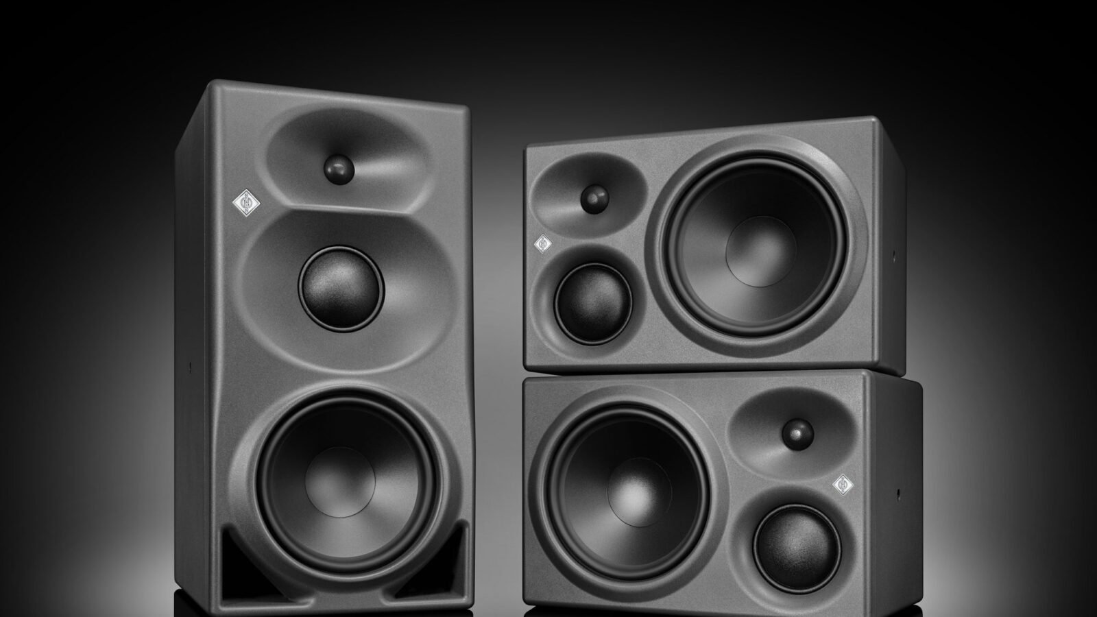 Monitores de estúdio Neumann KH 350 e KH 310 II lado a lado, com gabinete antracite e frente em policarbonato