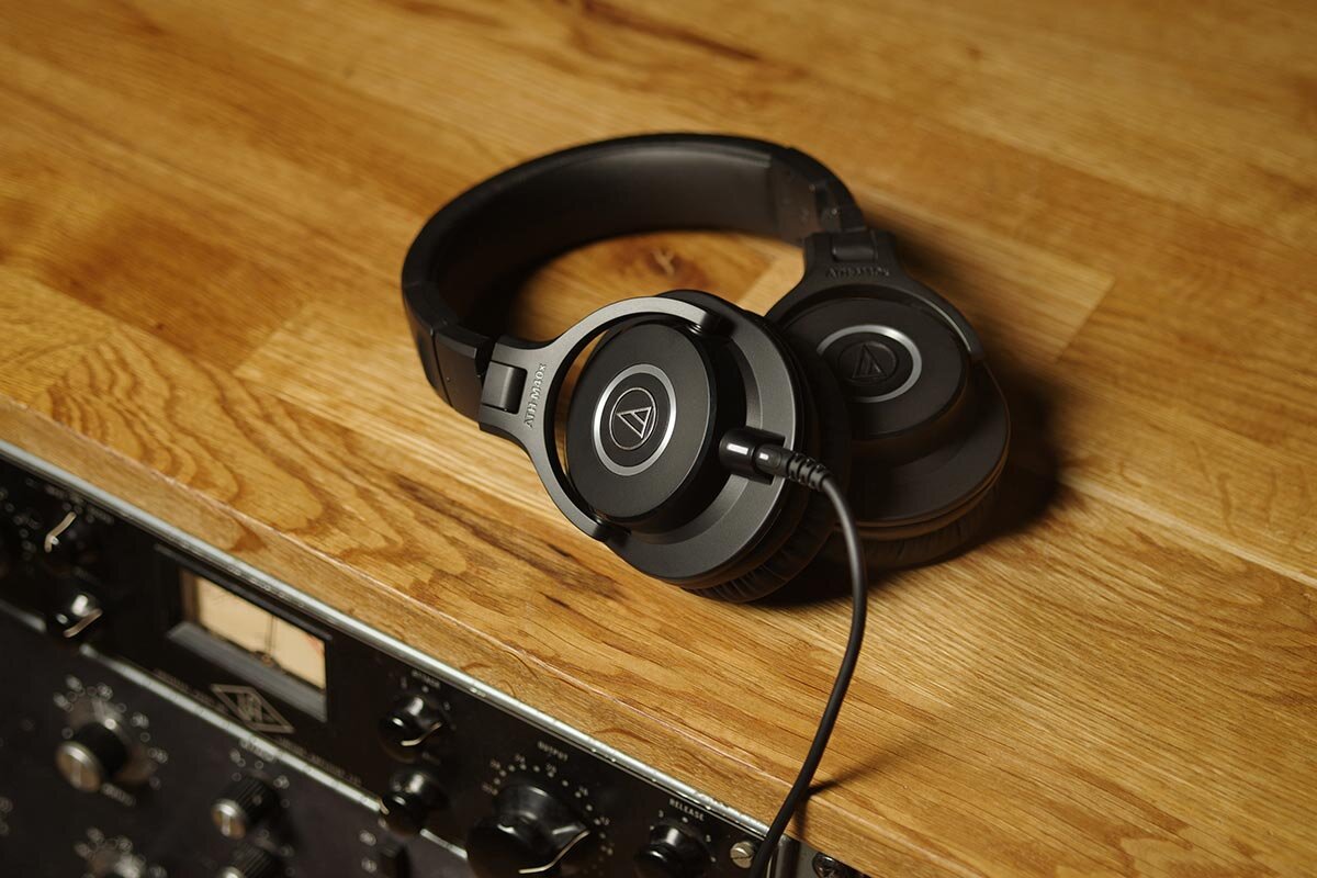 Fone de estúdio Audio-Technica ATH-M40x sobre mesa com equipamentos de gravação