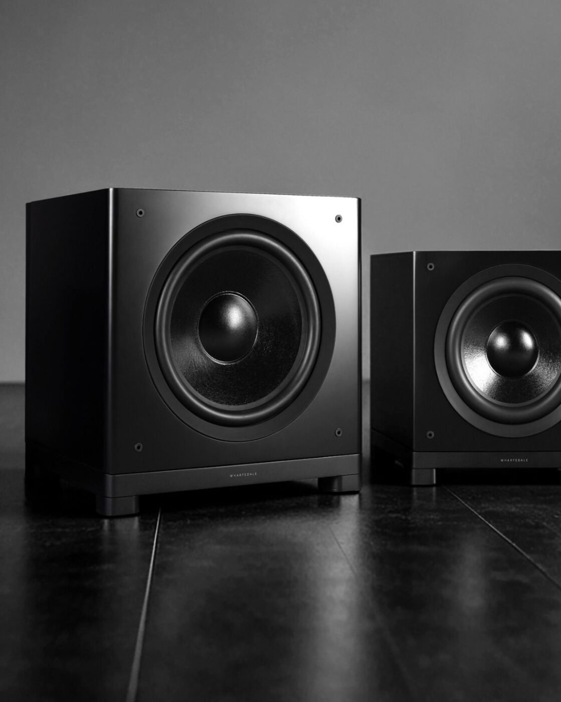 Subwoofers da série Wharfedale Nova em acabamento preto fosco, em quatro tamanhos lado a lado