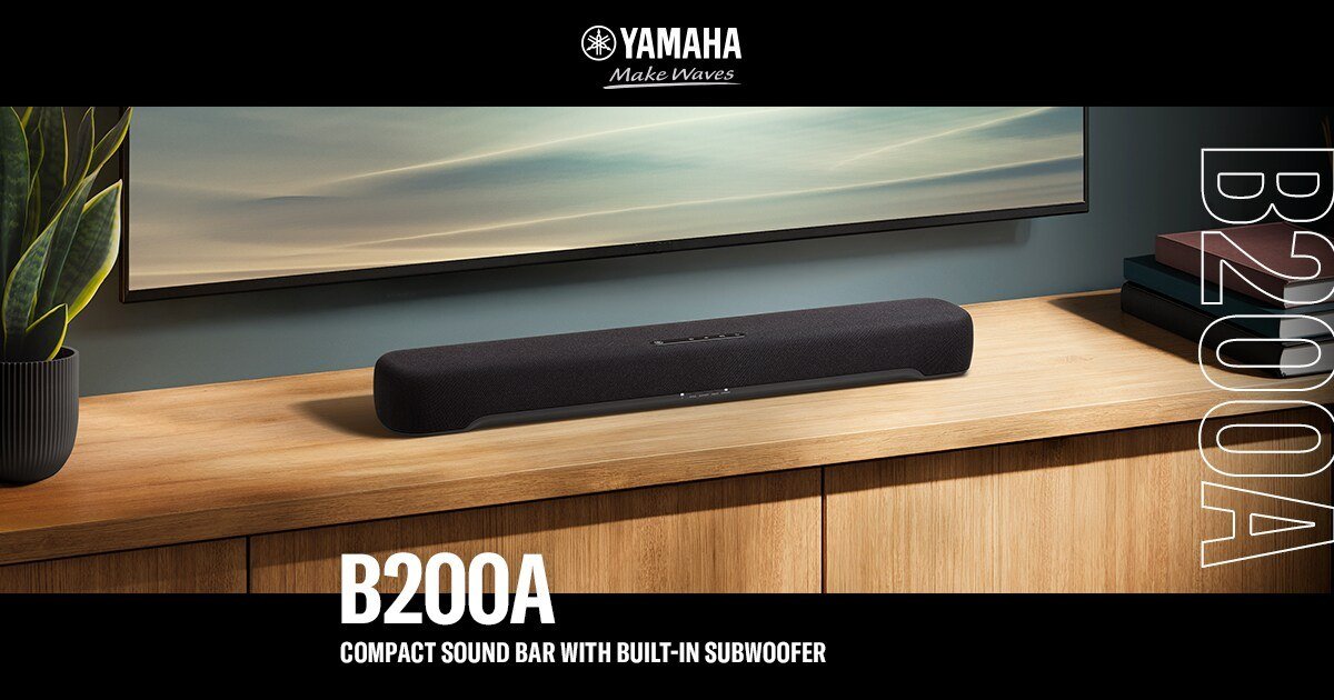 Soundbar compacta Yamaha B200A preta sobre rack de madeira, abaixo de uma TV, em imagem de divulgação da Yamaha