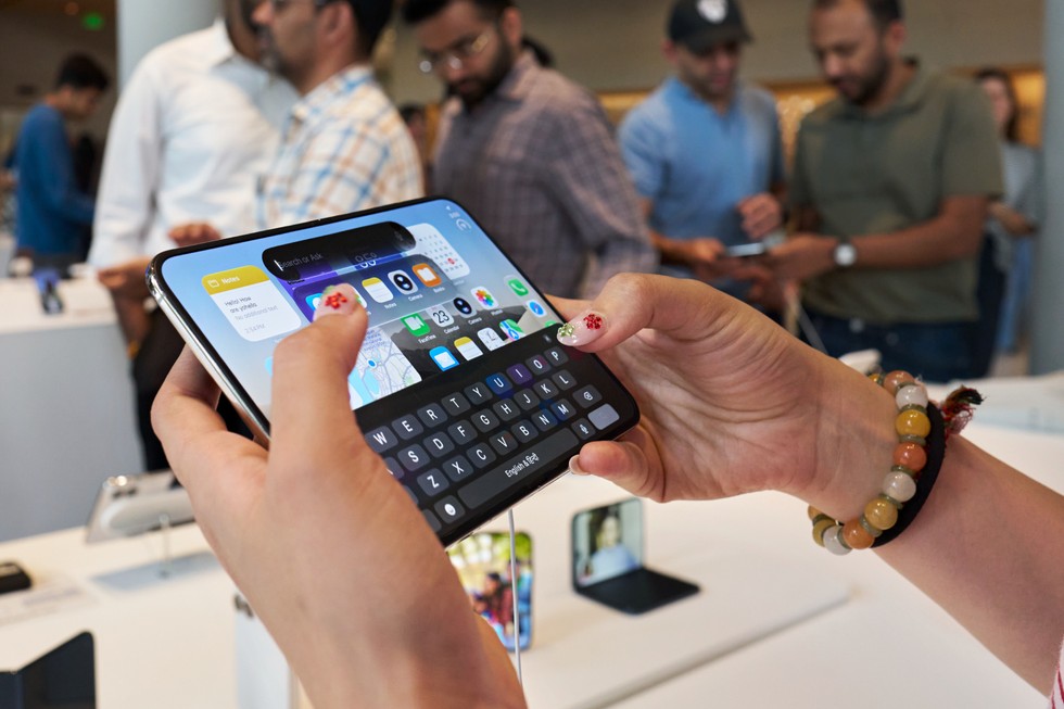 "Cliente testa o iPhone Duo, iPhone dobrável da Apple, aberto em uma Apple Store no lançamento de 23 de outubro"
