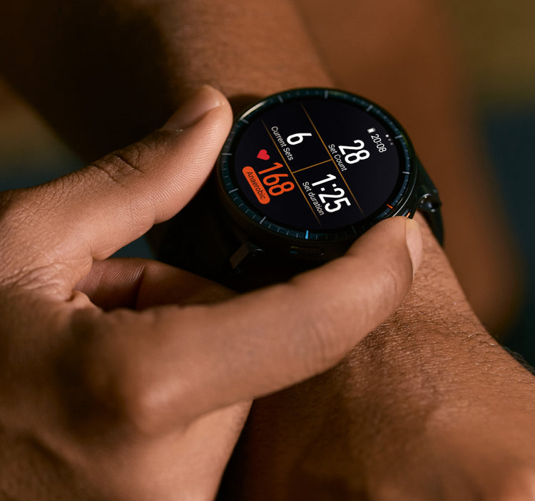 Pessoa tocando a tela redonda do smartwatch Amazfit Active Max no pulso, mostrando séries, repetições, tempo da série e frequência cardíaca de 168 bpm durante treino de força