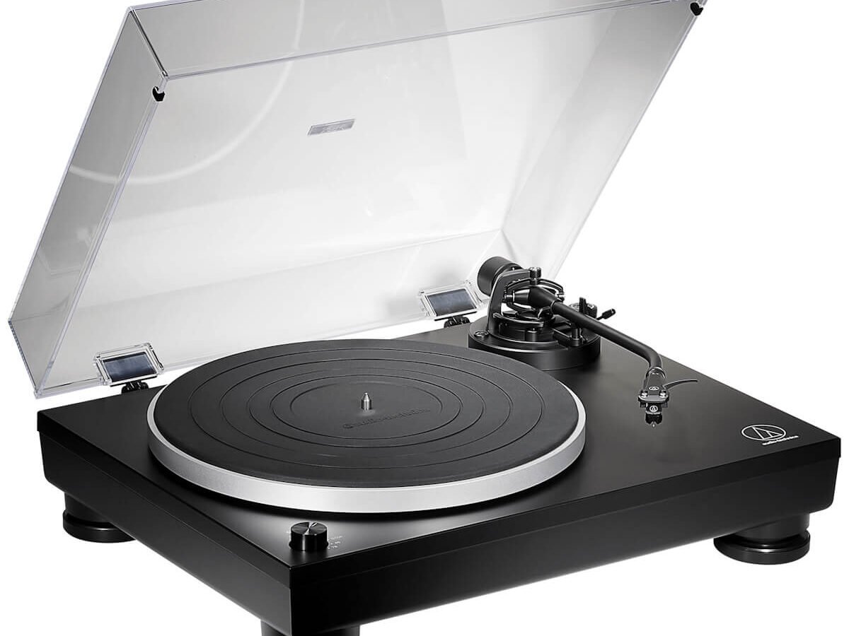Toca-discos Audio-Technica AT-LP5X preto com tampa de acrílico aberta, prato prateado com manta de borracha e braço em formato de J