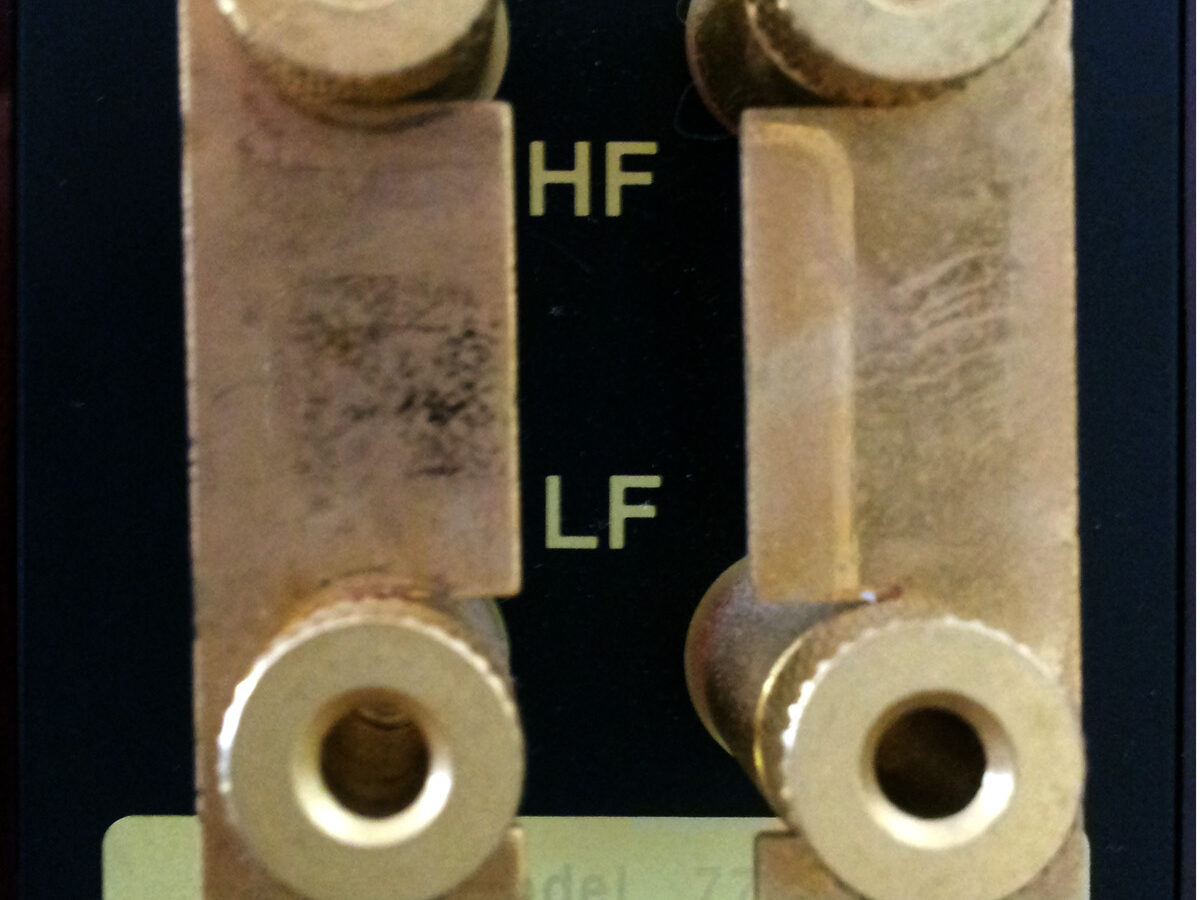 Bornes dourados duplos (HF e LF) com jumpers na traseira de uma caixa de som Quad