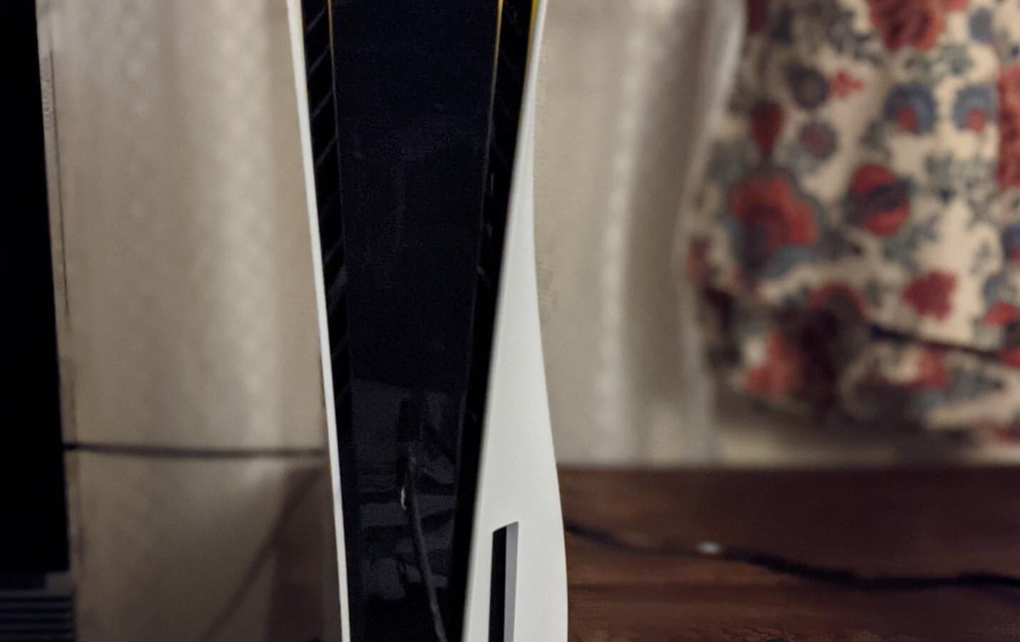 Console PlayStation 5 em pé ao lado do controle DualSense
