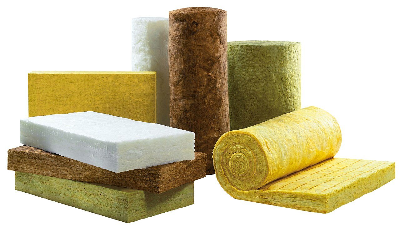 Placas, rolos e mantas de lã mineral de diferentes tipos e densidades empilhados sobre fundo branco