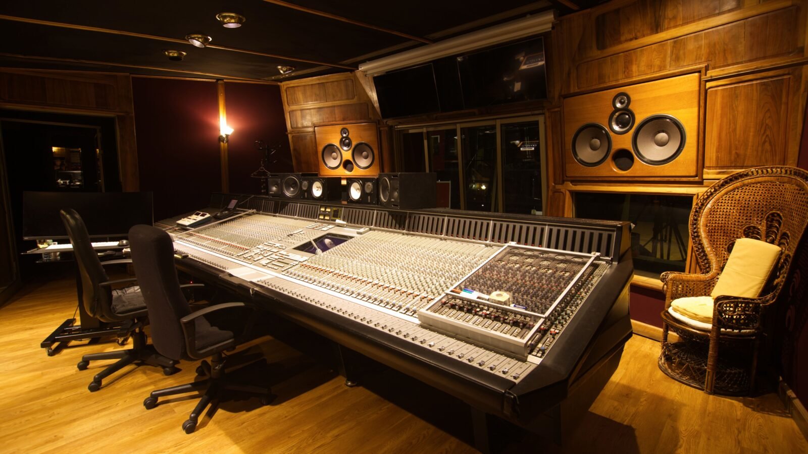 Sala de controle de estúdio com paredes tratadas acusticamente, monitores de referência e mesa de mixagem