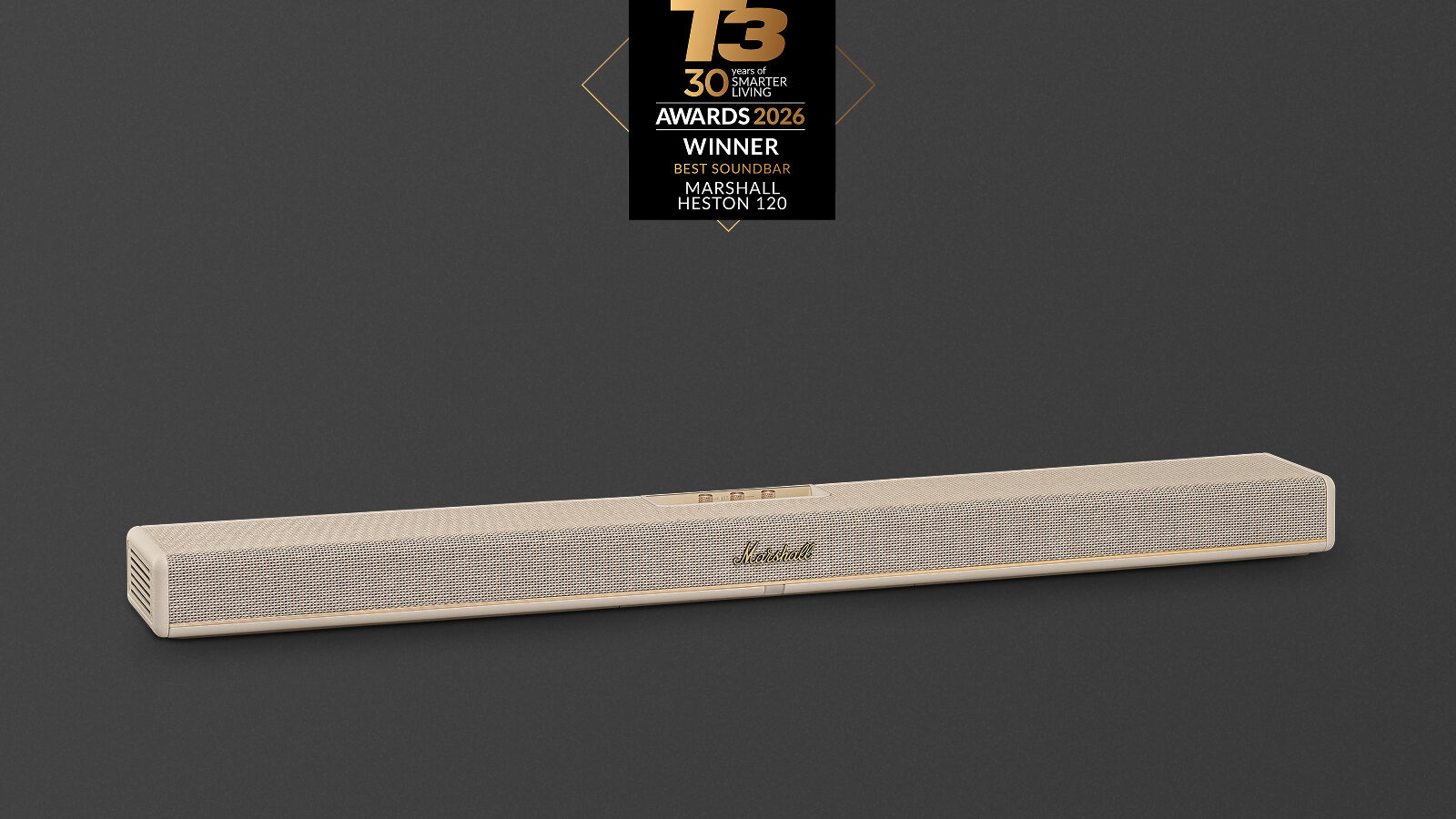 Soundbar Marshall Heston 120 na cor creme, com tela de tecido trançado e logotipo dourado, sobre fundo cinza-escuro