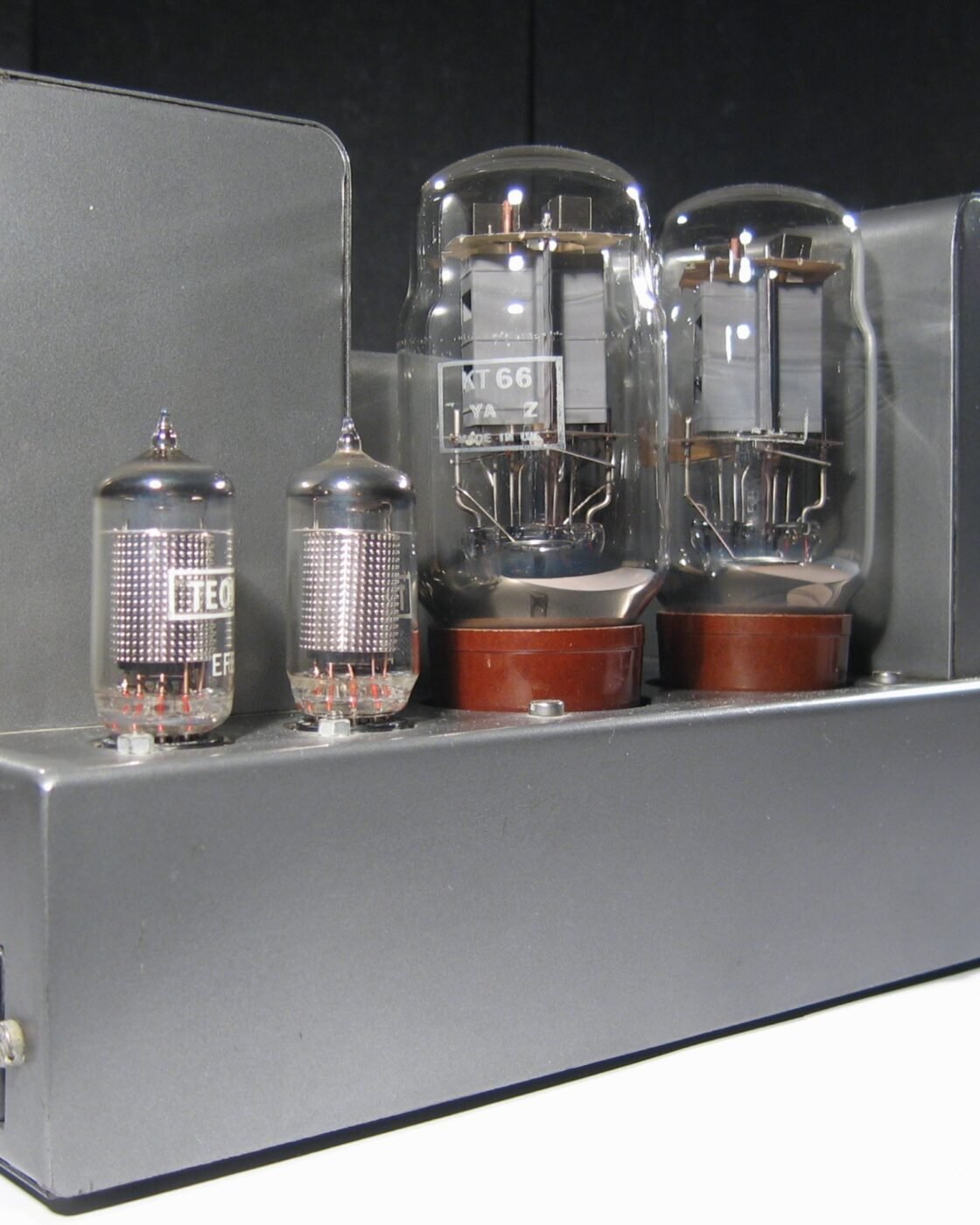 Amplificador valvulado Quad II, com duas válvulas KT66, duas EF86 e transformadores em gabinete cinza, fotografado sobre fundo escuro