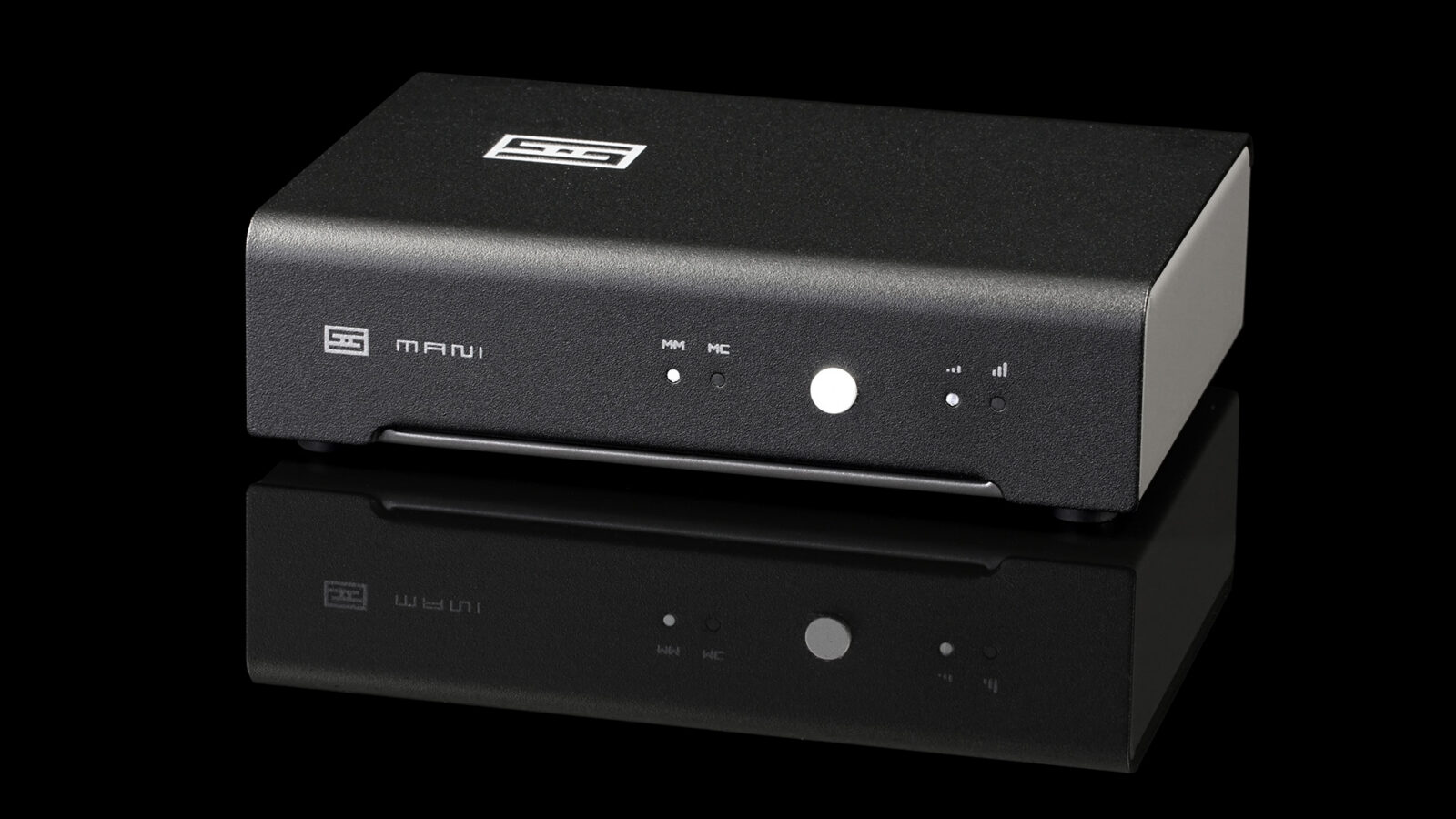 Pré-amplificador de phono Schiit Mani 3 preto, visto em ângulo frontal, com LEDs MM/MC, botão central e indicadores de ganho no painel