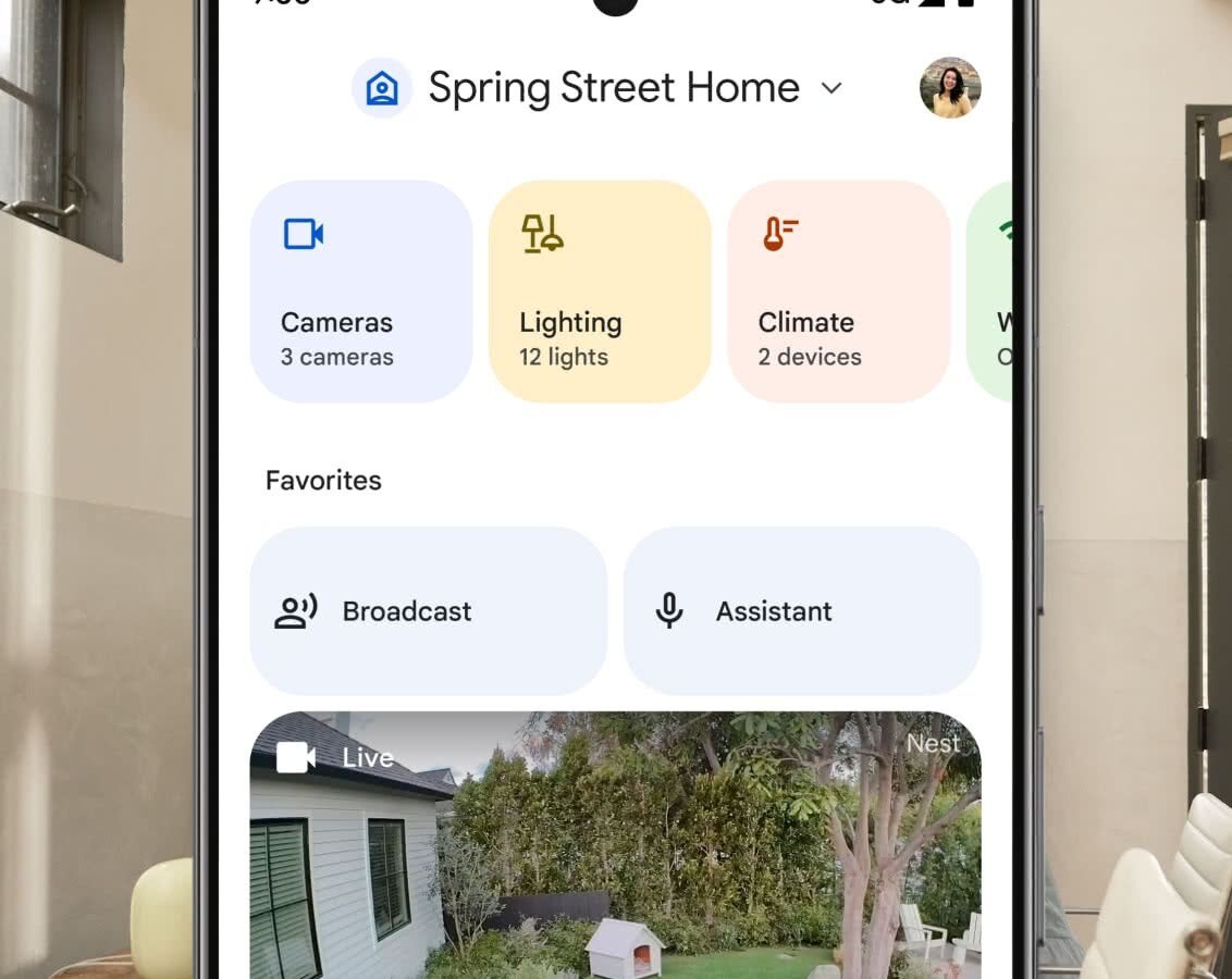Celular Android com o app Google Home aberto, mostrando blocos de Câmeras, Iluminação e Clima, atalhos de Transmitir e Assistente e a imagem ao vivo de uma câmera Nest no quintal com um cachorro
